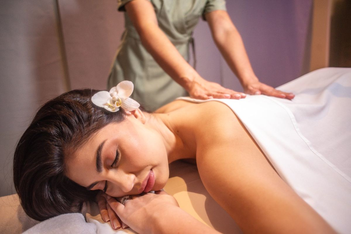 Cliente relaxando com orquídea no cabelo no Naturo Spa